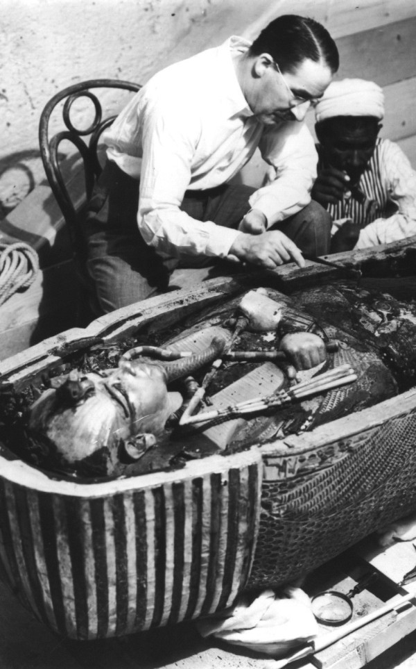Howard Carter, an English archaeologist, examining the opened sarcophagus of King Tut.