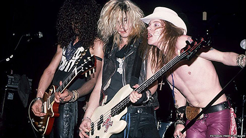 Slash, Duff McKagan и Axl Rose perform заедно на сцена во 1980.